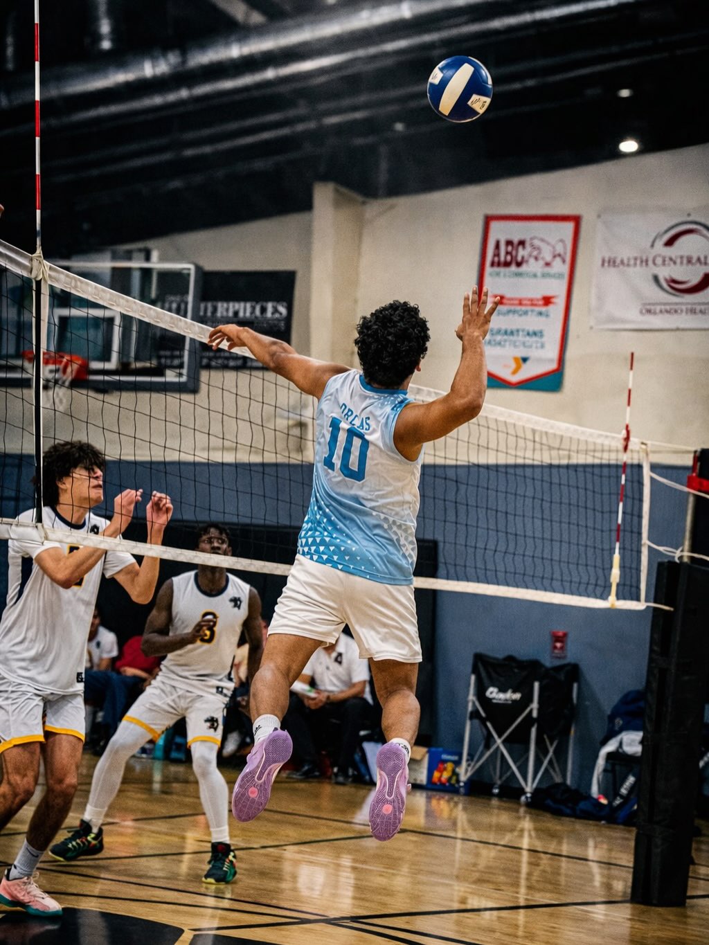Volleyball player rising above the net
